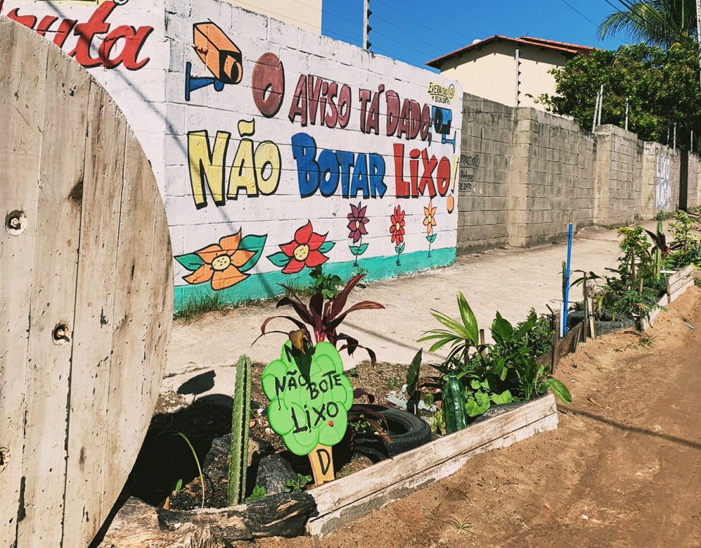 rua com muros pintados com frases sobre consciência ambiental